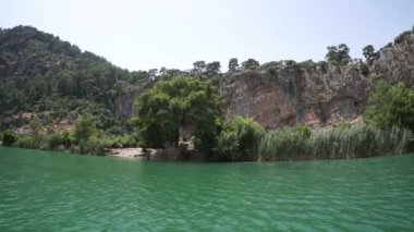 Mugla. Dalyan. Hindi. 28 Mayıs 2019, Lycia mezarlarının altındaki Dalyan Nehri 'nin ağzında turistlerle dolu bir tekne.