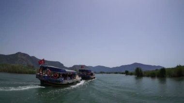 Mugla. Dalyan. Hindi. 28 Mayıs 2019, Lycia mezarlarının altındaki Dalyan Nehri 'nin ağzında turistlerle dolu bir tekne.