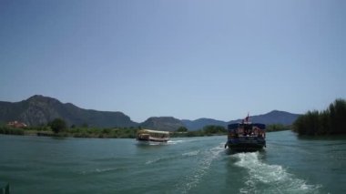 Mugla. Dalyan. Hindi. 28 Mayıs 2019, Lycia mezarlarının altındaki Dalyan Nehri 'nin ağzında turistlerle dolu bir tekne.