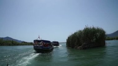 Mugla. Dalyan. Hindi. 28 Mayıs 2019, Lycia mezarlarının altındaki Dalyan Nehri 'nin ağzında turistlerle dolu bir tekne.