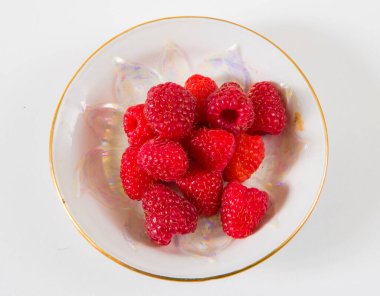 Beyaz arka planda bir tabakta ahududu.