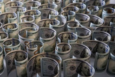 Yüzlerce dolarlık banknotlar beyaz arka planda toplanmış. Seçici odaklanma. Bulanık arkaplan.