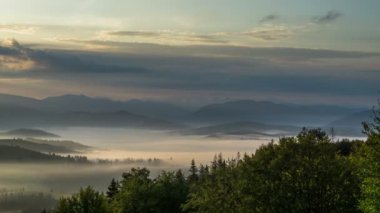 Dağlarda sisli bir gün doğumu. Bulutların hareketi.