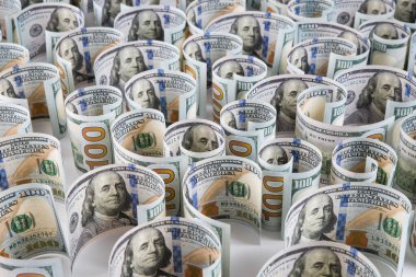 100 dolarlık banknotların yakın plan çekimleri beyaz arka planda yuvarlandı.