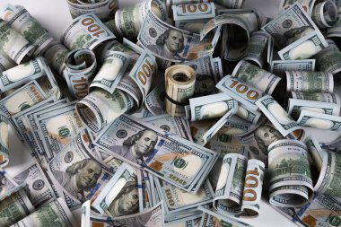 100 dolarlık banknotların yakın plan çekimleri beyaz arka planda yuvarlandı.