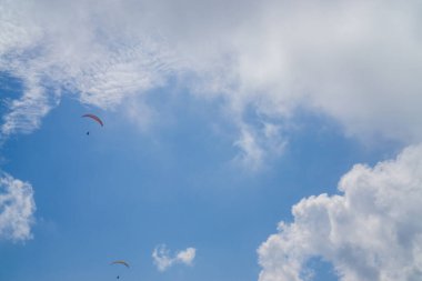 Bulutlu mavi gökyüzünde paragliding.