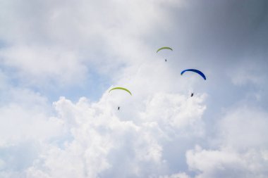 Bulutlu mavi gökyüzünde paragliding.