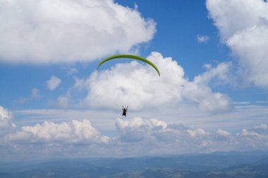 Bulutlu mavi gökyüzünde paragliding.