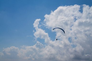 Bulutlu mavi gökyüzünde paragliding.