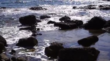Taşların arasında köpüklü deniz dalgaları