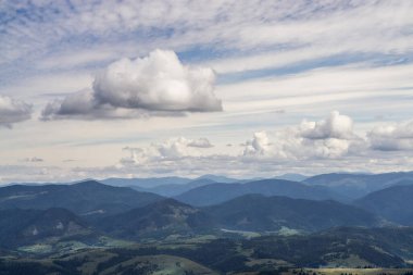 Bulutlu gökyüzü mavi dağların üzerinde.