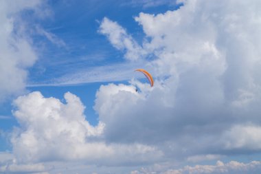 Bulutlu mavi gökyüzünde paragliding.