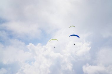 Bulutlu mavi gökyüzünde paragliding.