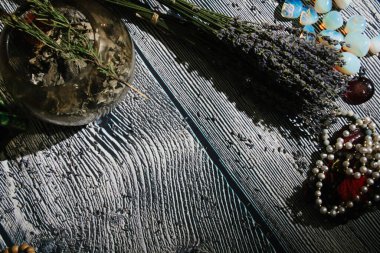 Doğaüstü özellikleri olan ahşap masa, üst görünüm. Rune taşları, mumlar, kuru lavanta, tespihler. Boş kopyalama alanı