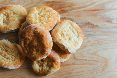 Evde yemek pişirmek, ahşap bir masada taze taze ekmek yığını.