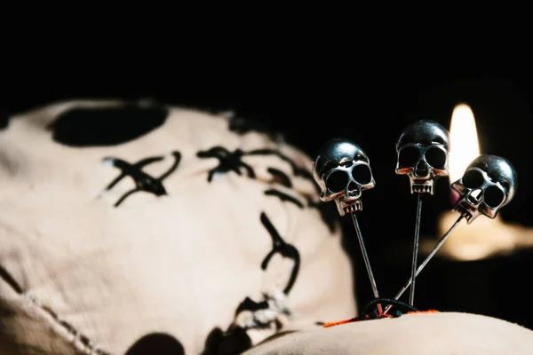 Voodoo sihirli ayin bebeğini kapatın. Siyah bir arka planda, ahşap bir masanın üzerinde mumlarla yatıyordu.