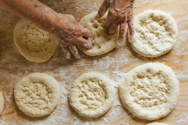 Evde yemek pişirmek, yaşlı bir kadının elleri ekmeği pişirmeye hazırlanıyor.