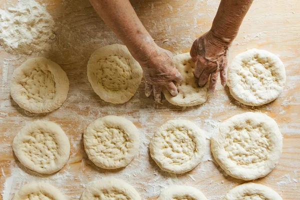Evde yemek pişirmek, yaşlı bir kadının elleri ekmeği pişirmeye hazırlanıyor.
