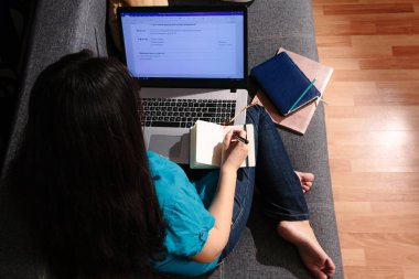 Evde çalış. Bilgisayarlı Asyalı kadın internette iş yapıyor.