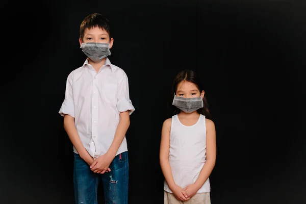Retrato Duas Crianças Asiáticas Máscaras Médicas Fundo Preto — Fotografia de Stock