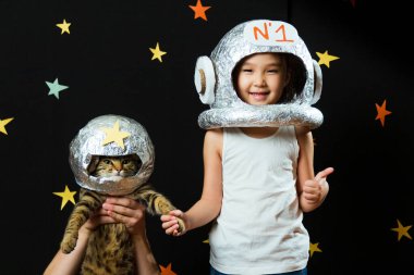 Kedisiyle birlikte küçük şirin bir Aisan kızın portresi, evde boş bir yer, hayal kurup astronotçuluk oynuyor. Komik aile anları