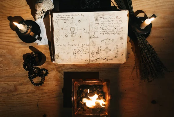 Occult white magic ritual of fire using grimoire, old book, candles
