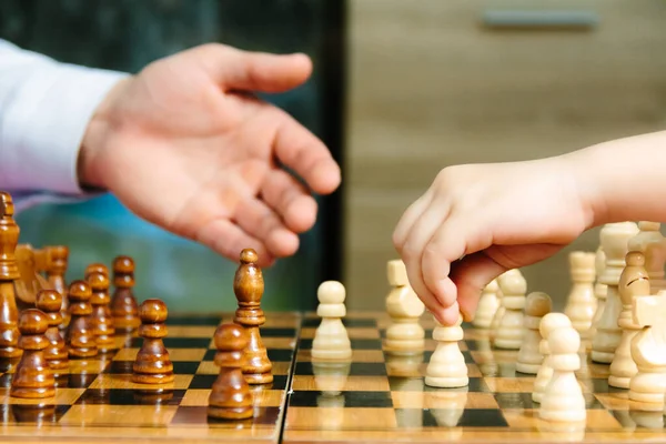 Satranç oynarken bir çocuğun elini kapat