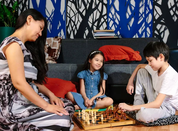 Sweet family moments during lockdown, mother and her children playing chess