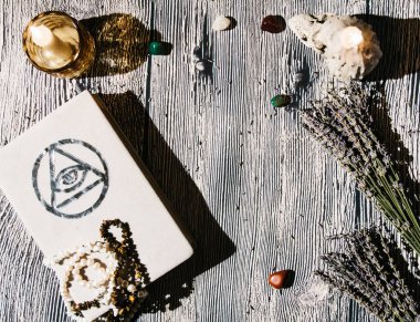 Masada beyaz büyü kitabı var. Tespihlerle, lavantalarla. Falcılık, ritüel, sunak, maneviyat, gizli bilgi