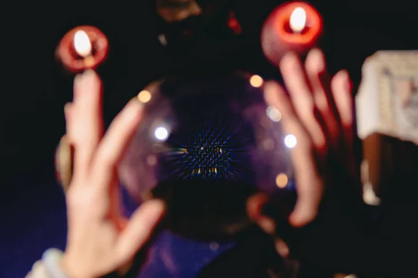 Fortuneteller\'s hand on a glass ball, crystal orb. Prediction of the future. Mystic interior. Occult symbols