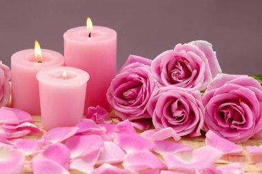 Üç pembe mum ve rose, yaprakları mat