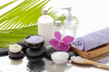 Spa konseptiyle palm, havlu, orkide, taşlar, petrol, kaşık tuz