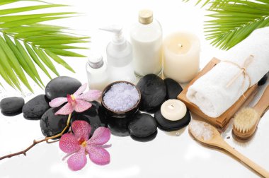 Spa konseptiyle palm, havlu, orkide, taşlar, petrol, kaşık tuz