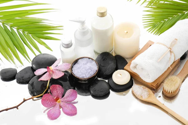 Spa konseptiyle palm, havlu, orkide, taşlar, petrol, kaşık tuz