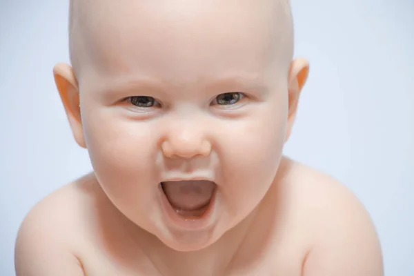 Hermoso retrato de cerca de un bebé feliz sobre un fondo uniforme — Foto de Stock