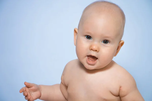 Hermoso retrato de cerca de un bebé feliz sobre un fondo uniforme — Foto de Stock