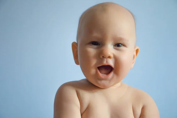 Hermoso retrato de cerca de un bebé feliz sobre un fondo uniforme — Foto de Stock