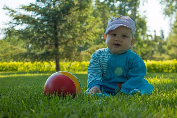 Baby Sitzt Mit Seinem Bunten Ball Auf Dem Weichen Gras — Stockfoto