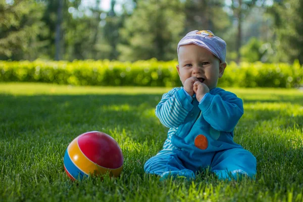 Baby Sitzt Mit Seinem Bunten Ball Auf Dem Weichen Gras — Stockfoto