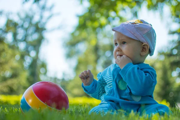 Baby Sitzt Mit Seinem Bunten Ball Auf Dem Weichen Gras — Stockfoto