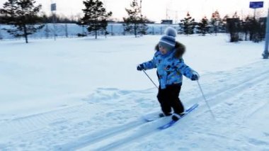 üç yaşında küçük bir çocuk akşam şehirde Park kaymaya öğrenir