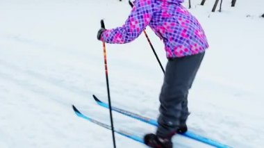 akşam şehirde Park Kayak öğrenmek için bir parlak pembe ceket 8 yaşında kız