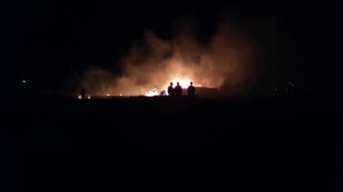 Gece parlayan bir ateş, insanların siluetleri, itfaiyecilerin işi, yavaş çekim