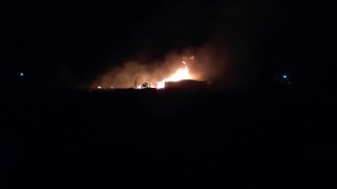 Gece parlayan bir ateş, insanların siluetleri, itfaiyecilerin işi, yavaş çekim