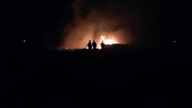 Gece parlayan bir ateş, insanların siluetleri, itfaiyecilerin işi, yavaş çekim