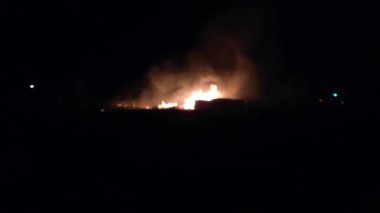Gece parlayan bir ateş, insanların siluetleri, itfaiyecilerin işi, yavaş çekim
