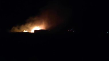 Gece parlayan bir ateş, insanların siluetleri, itfaiyecilerin işi, yavaş çekim