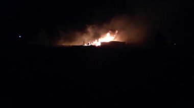 Gece parlayan bir ateş, insanların siluetleri, itfaiyecilerin işi, yavaş çekim