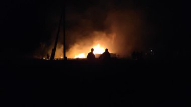 Gece parlayan bir ateş, insanların siluetleri, itfaiyecilerin işi, yavaş çekim