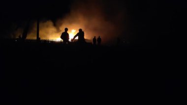 Gece parlayan bir ateş, insanların siluetleri, itfaiyecilerin işi, yavaş çekim